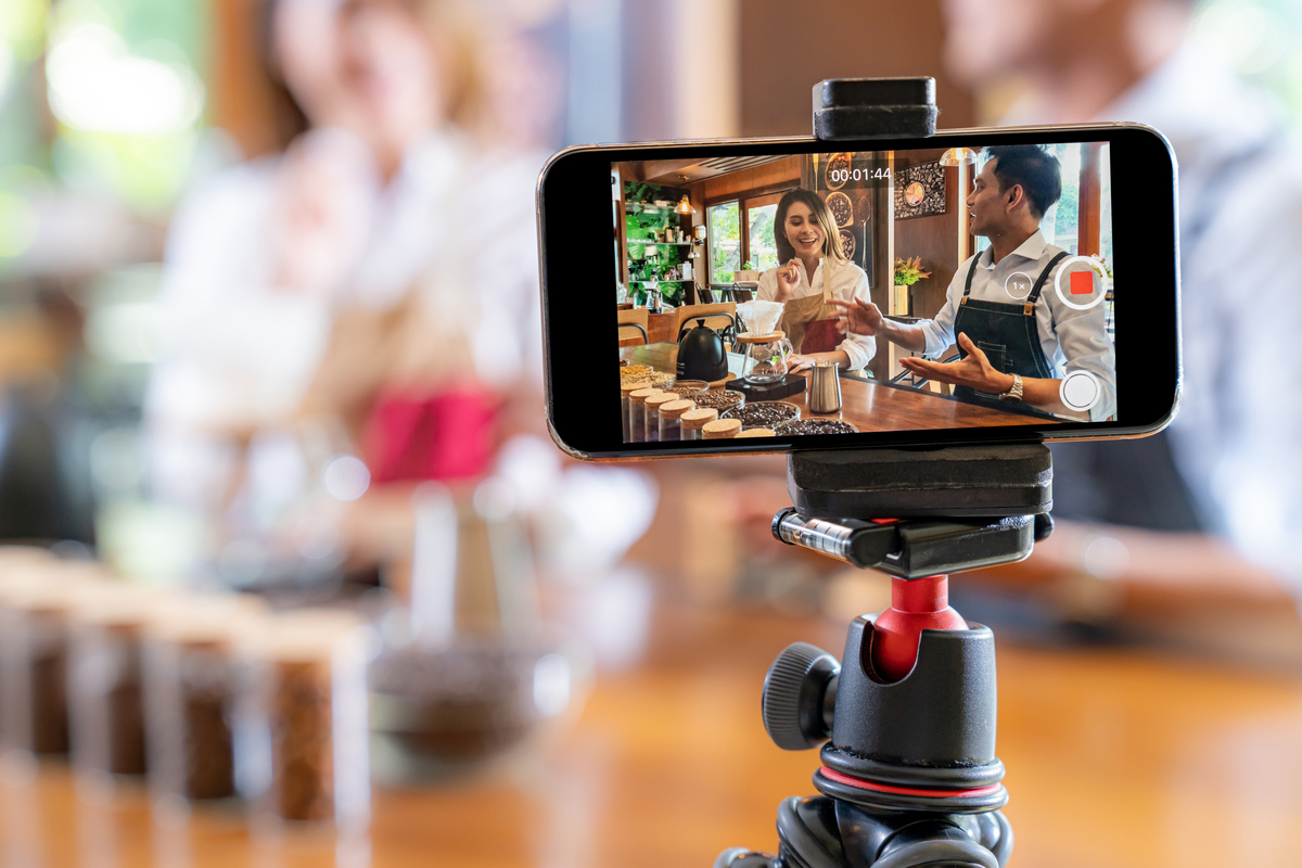 Cell phone on tripod videoing two people cooking