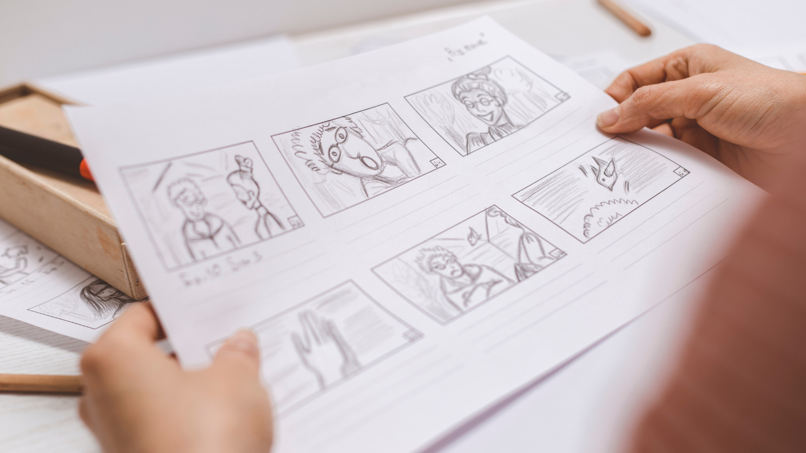 A person looking at a penciled storyboard
